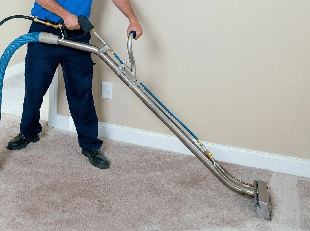Professional operating a liquid removal machine on a carpeted floor in Lincoln, NE